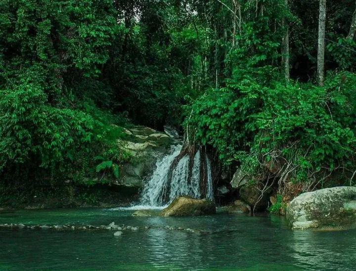 Keindahan Alam Air Terjun Air Melancar di Puncak Hijau